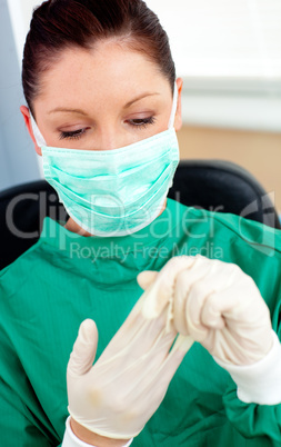 Beautiful female doctor with scrubs getting off her gloves