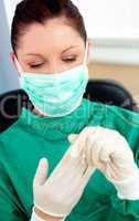 Beautiful female doctor with scrubs getting off her gloves