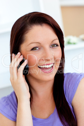 Laughing woman using her cellphone at home