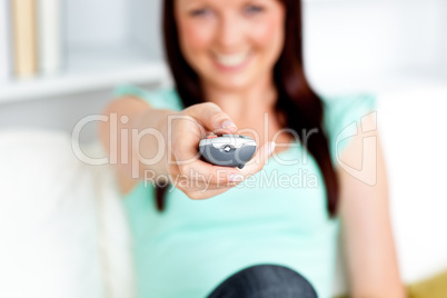 Close-up of a caucasian woman hoding a remote in the living-room