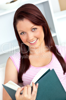 Smiling woman reading a book at home