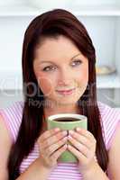 Positive woman holding a cup of coffee at home