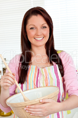 Smiling woman cooking a cake at home