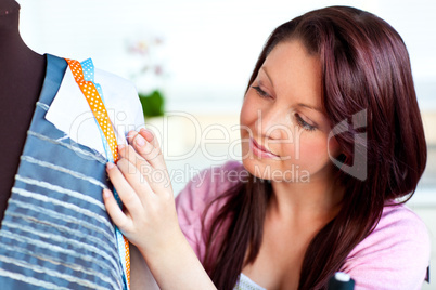Young caucasian woman sewing in the kitchen