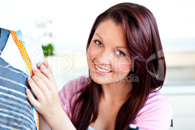 Smiling caucasian woman sewing in the kitchen
