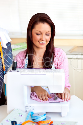 Bright caucasian woman using a sewing-machine in the kitchen