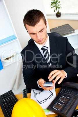 Concentrated businessman using his calculator