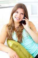 Glowing woman talking on phone at home
