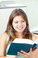 Bright caucasian woman reading a book at home