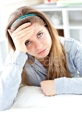 Depressed young woman sitting in the kitchen
