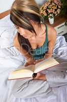 Frau mit Buch im Bett