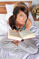 Frau mit Buch im Bett