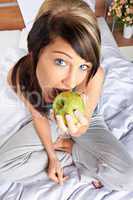 Frau mit Apfel im Bett