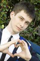 Teen boy making heart shape with hands