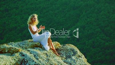 A beautiful girl sitting on a rock