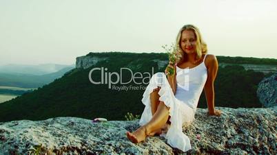 Girl sits on the edge of the cliff