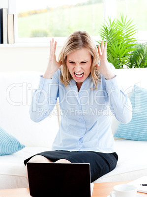 Young businesswoman sitting on her sofa getting frustrated with