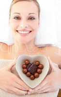 Cheerful woman holding a bowl in the shape of a heart with choco