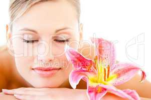 Close-up of a pretty woman lying on a massage table with a flowe