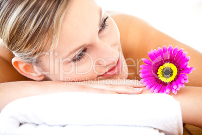 Close-up of a bright woman lying on a massage table with a flowe