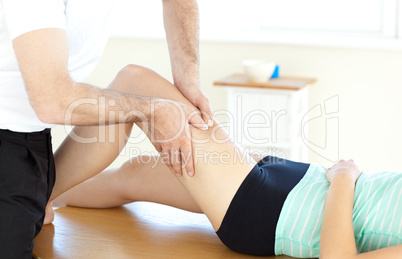 Young physical therapist giving a leg massage