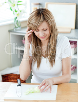 Pretty young woman cutting onions in the kitchen