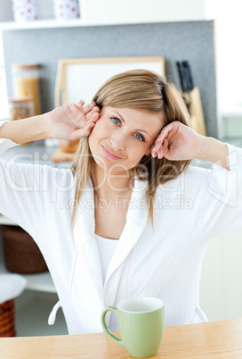 Beautiful woman holding a cup of coffee in the kitchen