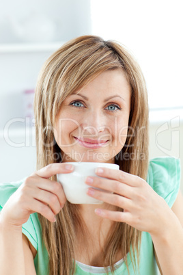 Bright woman holding a cup of coffee in the kitchen