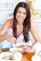 Beautiful asian woman having breakfast smiling at the camera sit