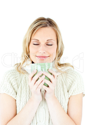 Happy blond woman wearing a pullover and holding a cup of coffee