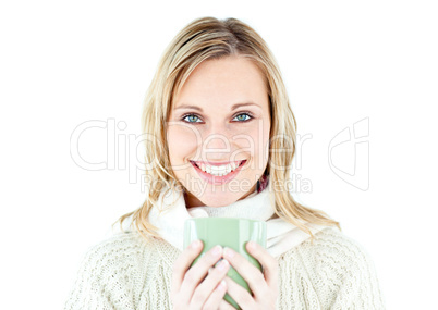 Smiling blond woman wearing a pullover and holding a cup of coff