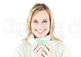 Smiling blond woman wearing a pullover and holding a cup of coff