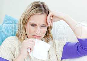 Diseased woman lying on a sofa with tissues