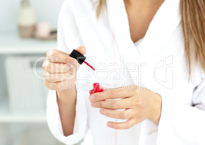 Close-up of a caucasian woman varnishing her fingernails in the