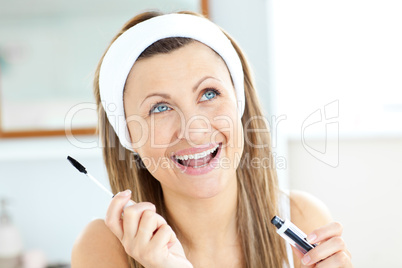 Radiant caucasian woman using mascara in the bathroom