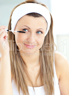 Caucasian woman using mascara in the bathroom