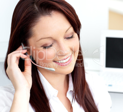 Glowing young businesswoman wearing headphones smiling at the ca