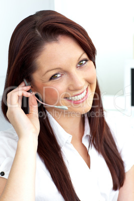 Charming young businesswoman wearing headphones smiling at the c