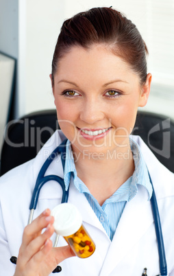Close-up of a smiling female doctor holding pills