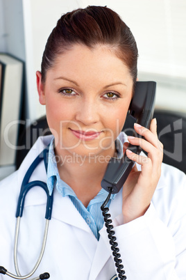 Portrait of an assertive female doctor phoning in her office