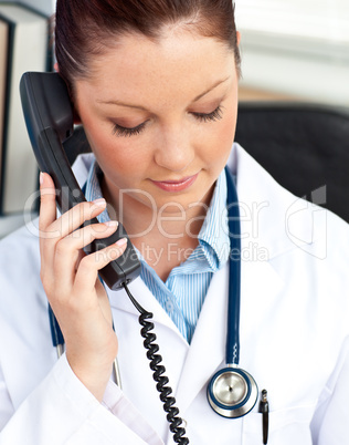 Portrait of a serious female doctor phoning in her office