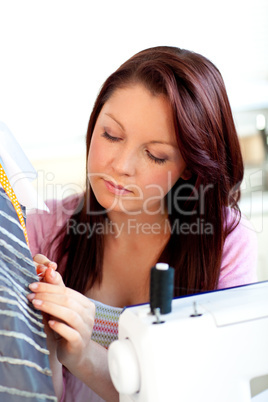 Serious caucasian woman sewing at home
