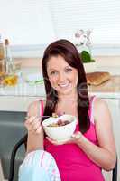 Charming woman eating her breakfast at home