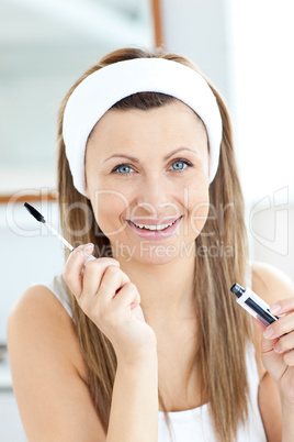 Radiant young woman using mascara in the bathroom