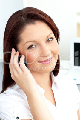 Smiling businesswoman talking on phone sitting