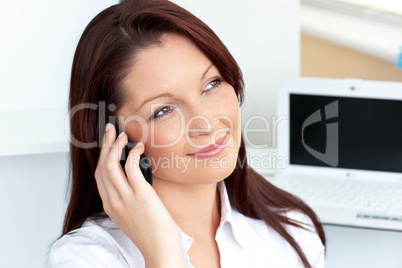 Cheerful businesswoman talking on phone sitting