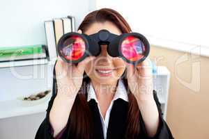 Radiant businesswoman sitting on a chair and looking through bin