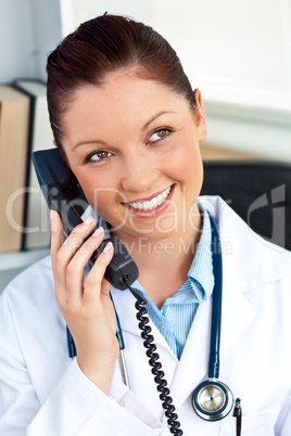 Delighted female doctor talking on phone