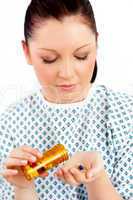 Caucasian female patient holding pills