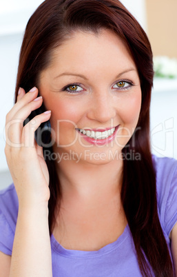 Delighted young woman using her cellphone on a sofa